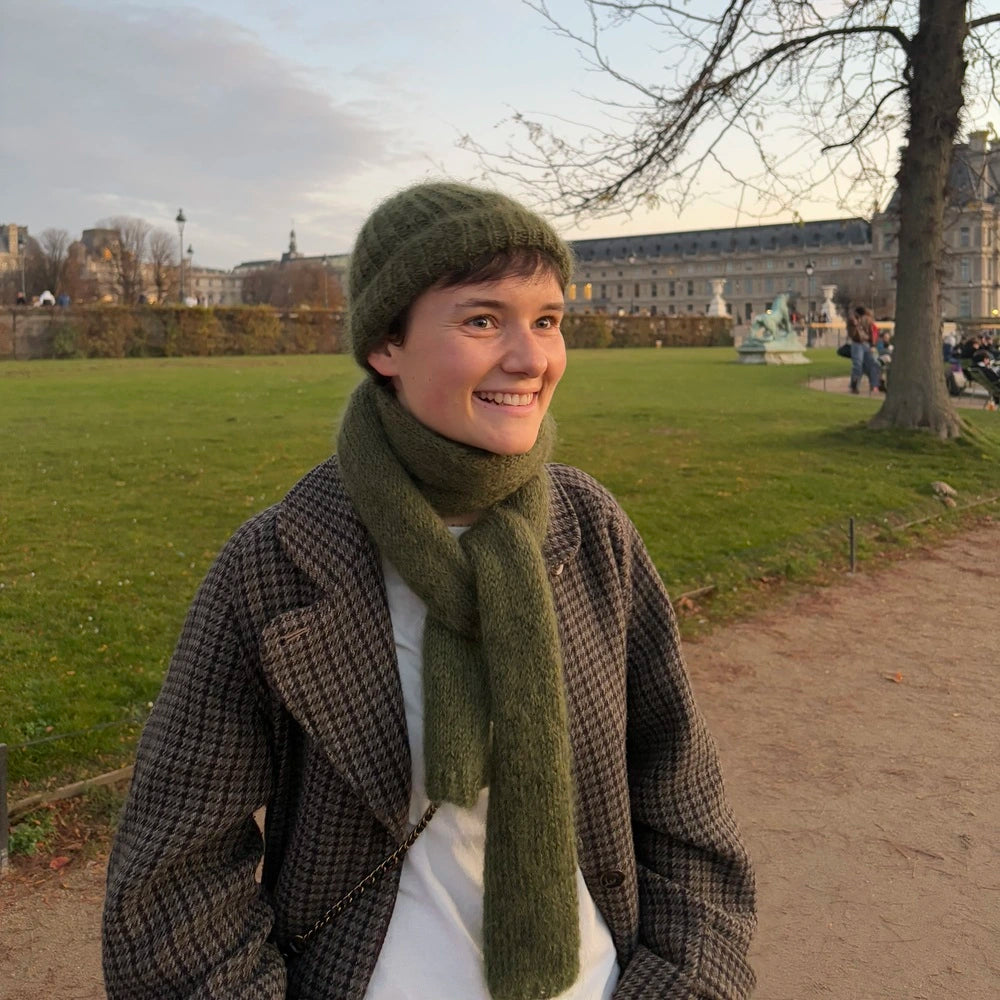 femme portant un bonnet et une écharpe en mohair vert kaki au jardin des tuileries