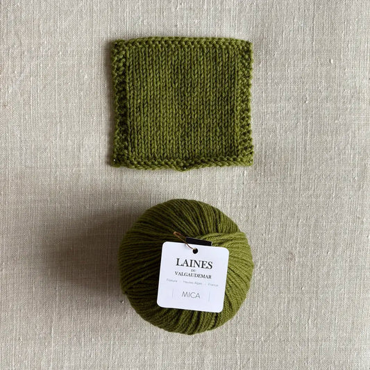 Pelote Mica de laine et mohair coloris alpage des Laines du Valgaudemar – boutique Tricotant, vue de dessus sur fond lin avec échantillon tricoté