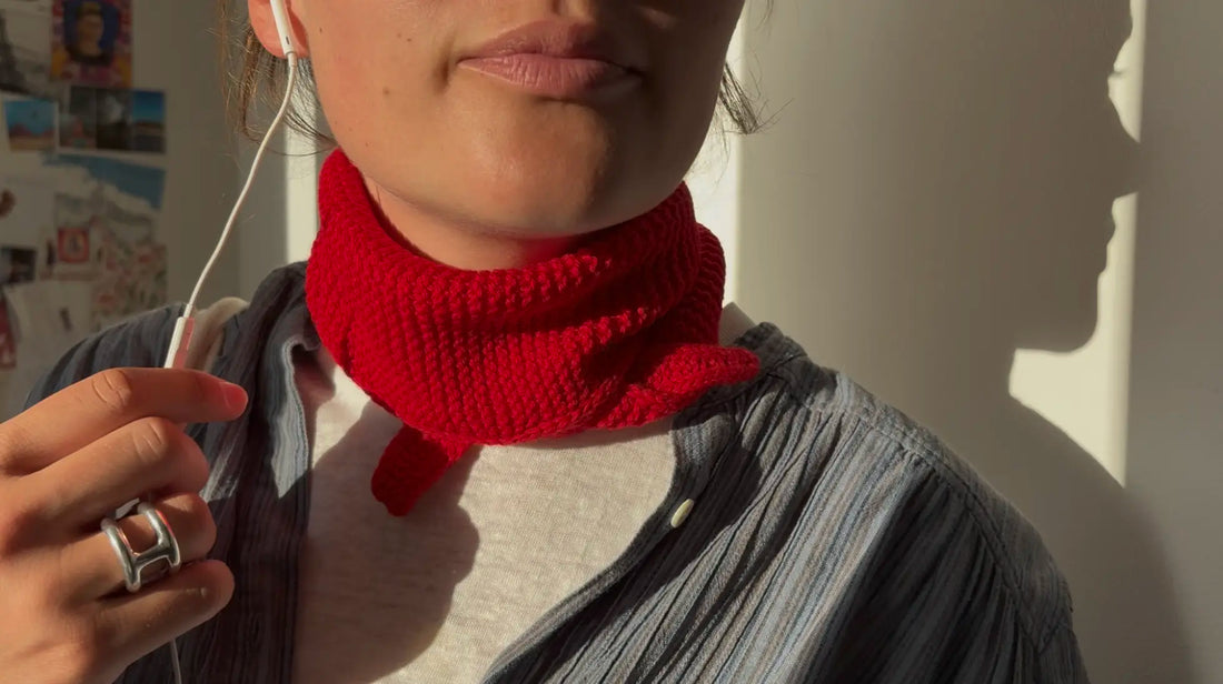 femme coupée en photo au-dessus de la bouche portante un foulard sophie scarf rouge au soleil