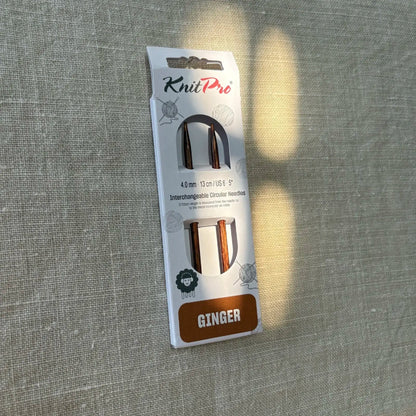 emballage d'aiguilles circulaires interchangeables taille 4 ginger knit pro sur fond lin beige avec rayon de soleil par tricotant