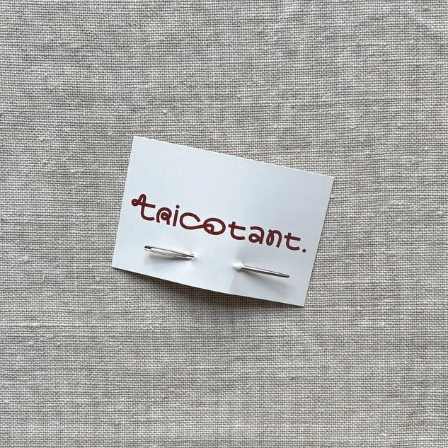 aiguille à laine piquée dans une carte de visite tricotant