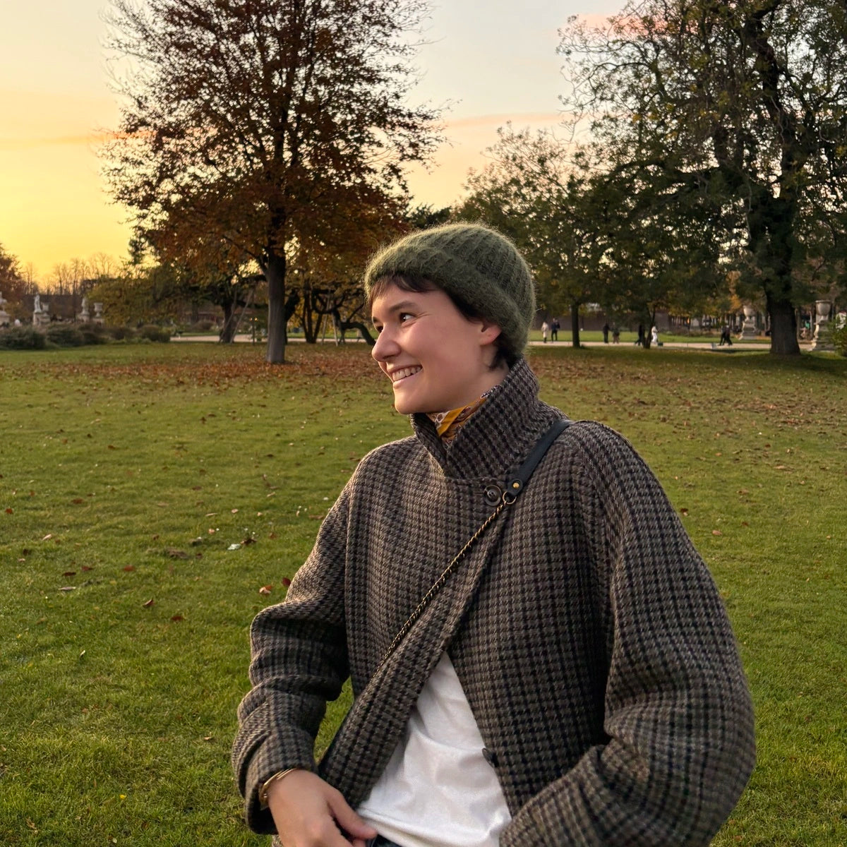 femme souriant portant un bonnet en mohair au coucher du soleil