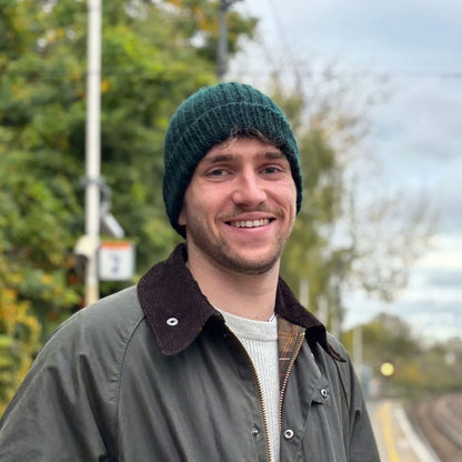 homme souriant portant un bonnet vert en laine