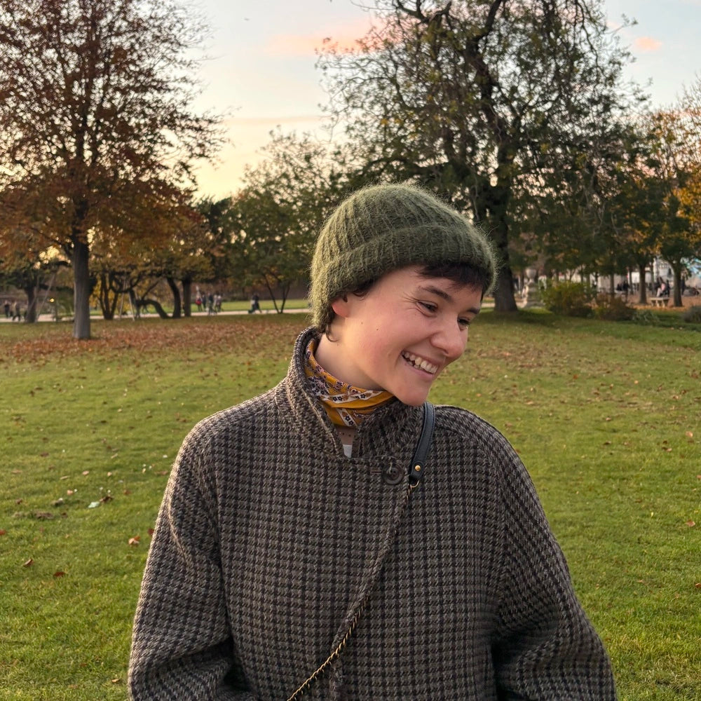 femme souriant et regardant vers la gauche portant un bonnet en mohair vert kaki