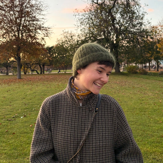 femme souriant et regardant vers la gauche portant un bonnet en mohair vert kaki