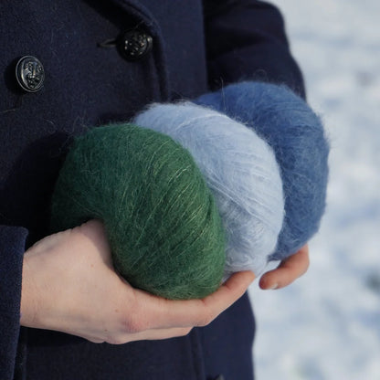 3 pelote tenues dans les mains d'une personne : vert forêt, bleu ciel et bleu vintage