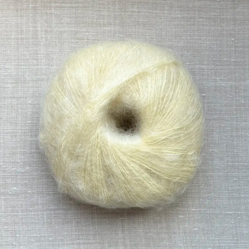 pelote de laine mohair à tricoter de la marque fonty, de couleur jaune beurre sur fond de lin beige par tricotant