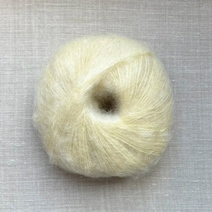 pelote de laine mohair à tricoter de la marque fonty, de couleur jaune beurre sur fond de lin beige par tricotant