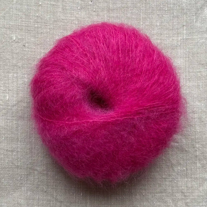 pelote de laine mohair à tricoter de la marque fonty, de couleur rose fluo magenta sur fond de lin beige