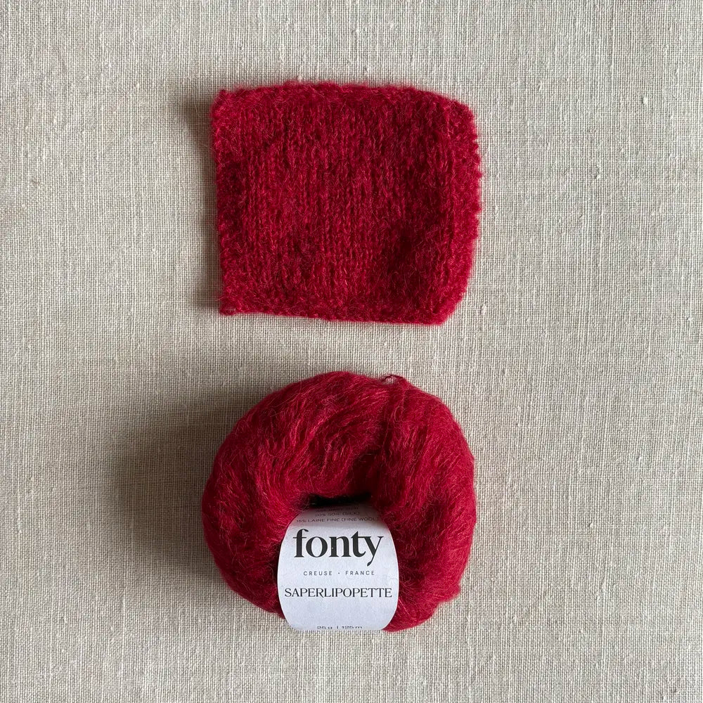 Pelote de laine Saperlipopette coloris fraise écrasée de Fonty – boutique Tricotant, vue de dessus sur fond lin avec échantillon tricoté