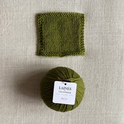 Pelote Mica de laine et mohair coloris alpage des Laines du Valgaudemar – boutique Tricotant, vue de dessus sur fond lin avec échantillon tricoté