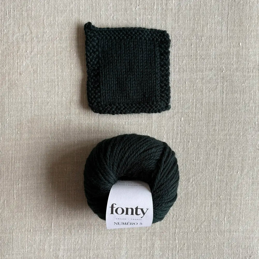 Pelote de laine Numéro 5 coloris vert profond de Fonty – boutique Tricotant, vue de dessus sur fond lin avec échantillon tricoté