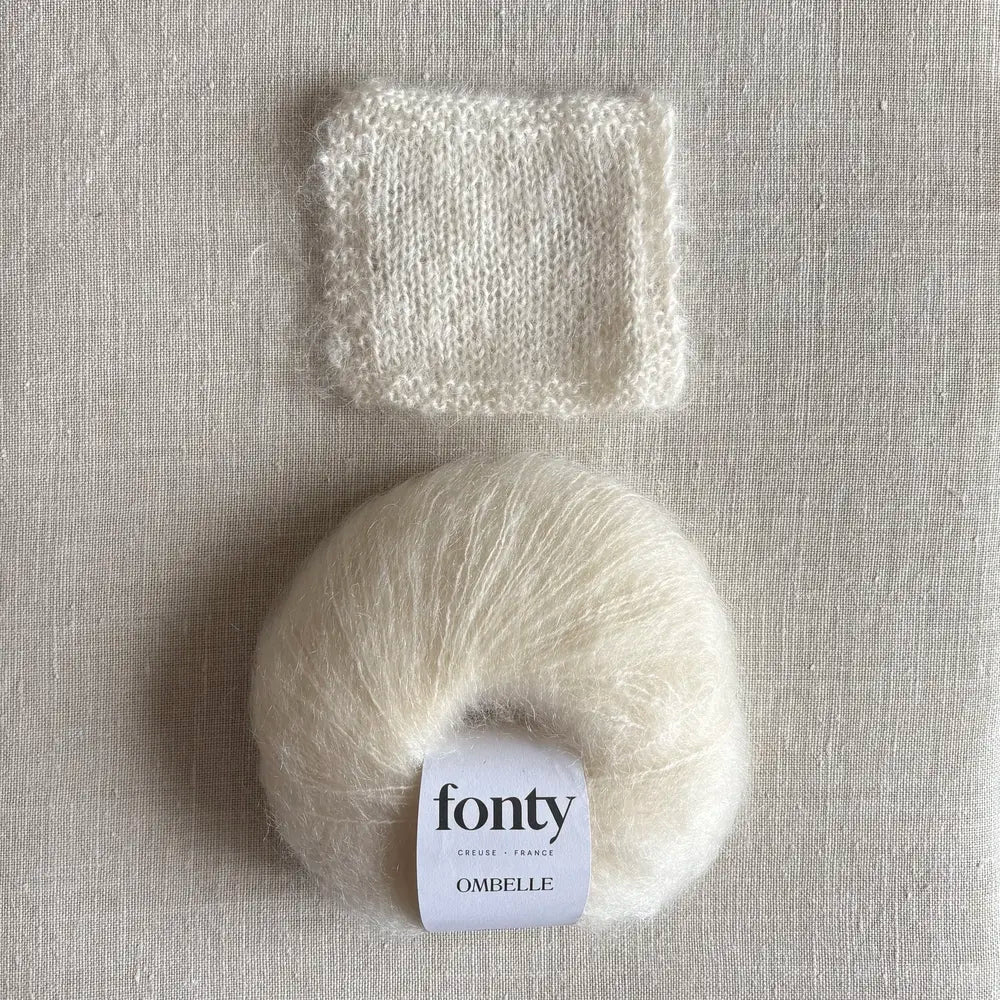 Pelote de laine mohair Ombelle coloris écru de Fonty – boutique Tricotant, vue de dessus sur fond lin avec échantillon tricoté