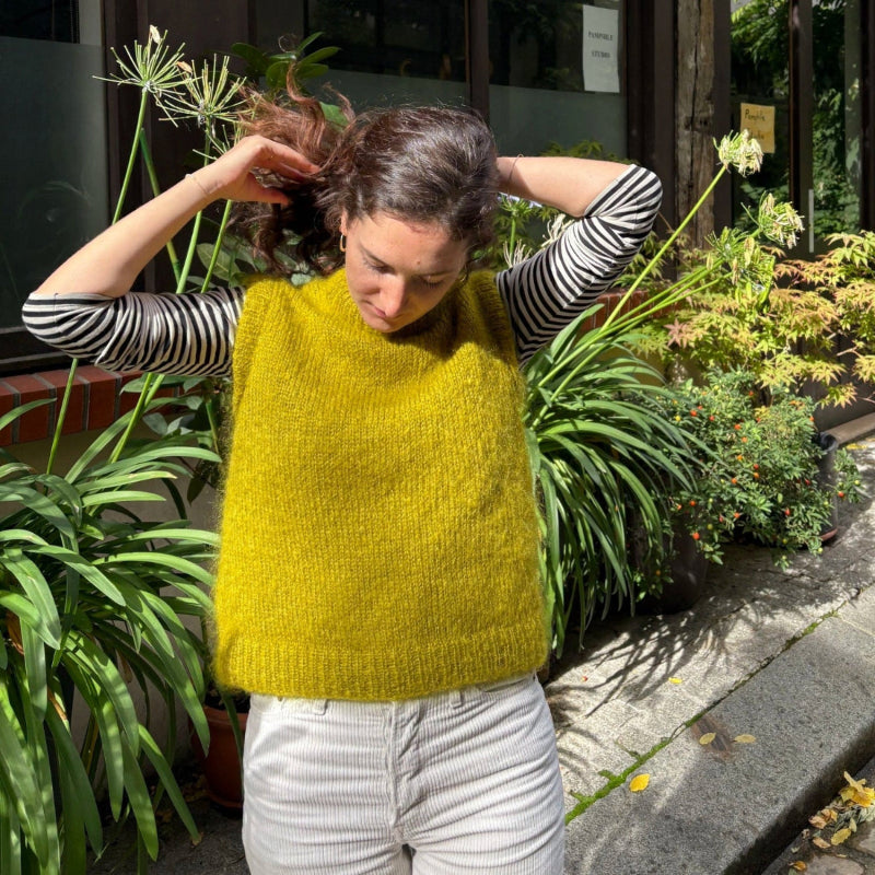 femme portant un pull sans manches tricoté à la main de couleur vert olive