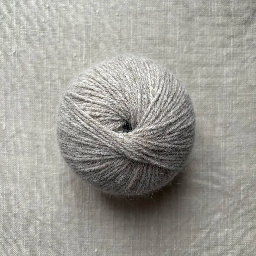 pelote de laine beige sur fond lin