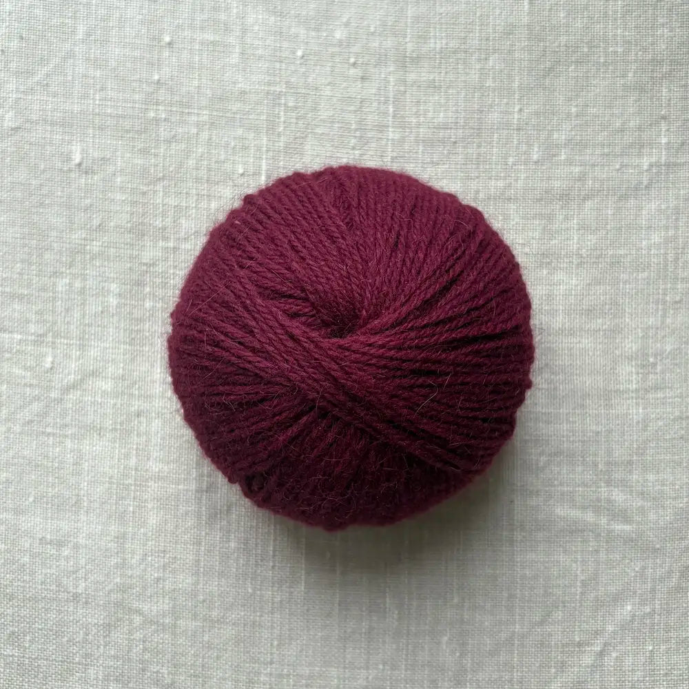 pelote de laine bordeaux sur fond lin