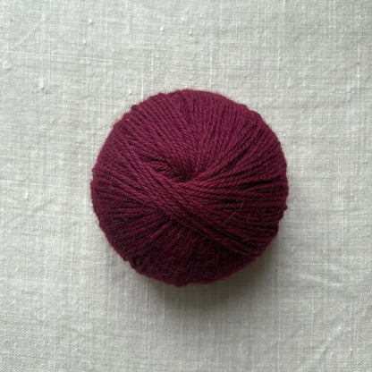 pelote de laine bordeaux sur fond lin