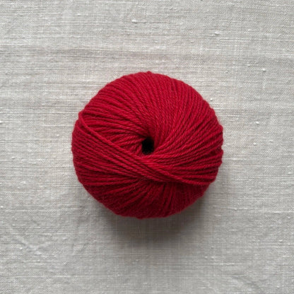 pelote de laine rouge sur fond lin