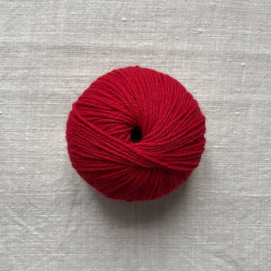 pelote de laine rouge sur fond lin